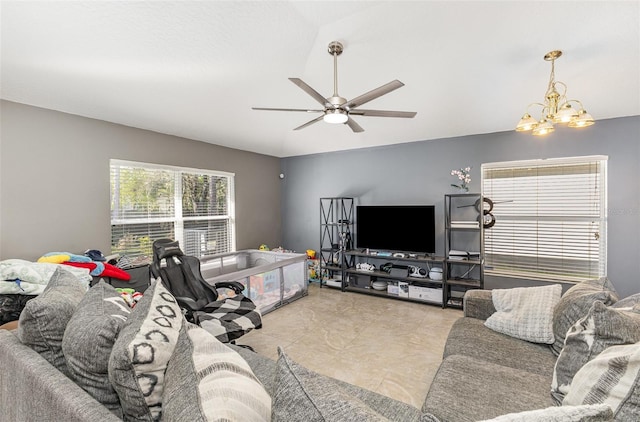 living area with ceiling fan with notable chandelier