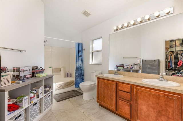 bathroom with toilet, double vanity, visible vents, and a sink