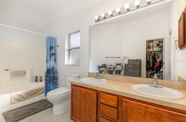 full bathroom featuring double vanity, shower / bath combo with shower curtain, a sink, and toilet