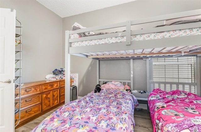 bedroom with a textured ceiling and wood finished floors