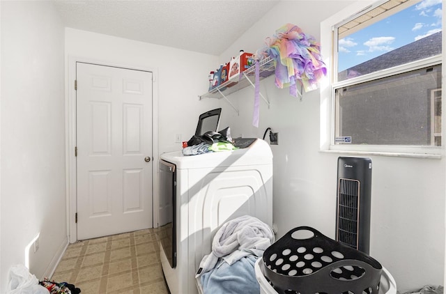 washroom featuring a textured ceiling, laundry area, light floors, and washing machine and dryer