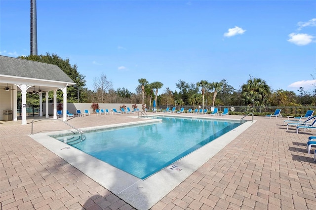 view of swimming pool featuring ceiling fan and a patio