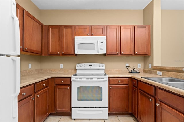 kitchen featuring sink, white appliances, and light tile patterned floors