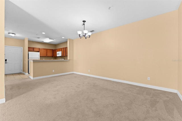 unfurnished living room with light carpet and a notable chandelier