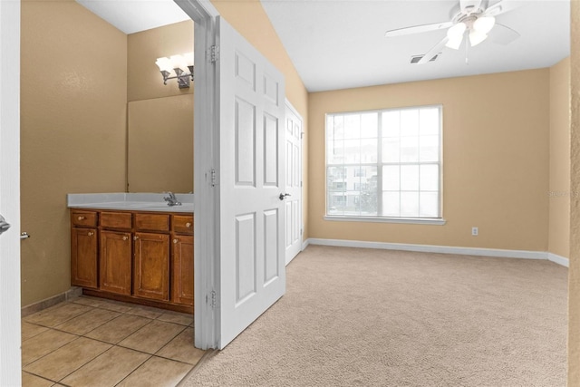 bathroom with tile patterned floors, vanity, and ceiling fan