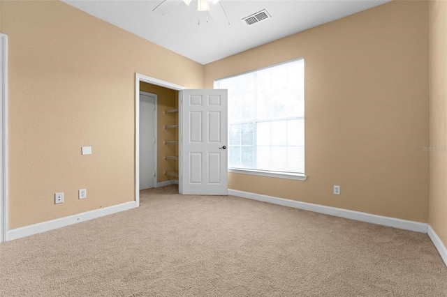 carpeted spare room with ceiling fan