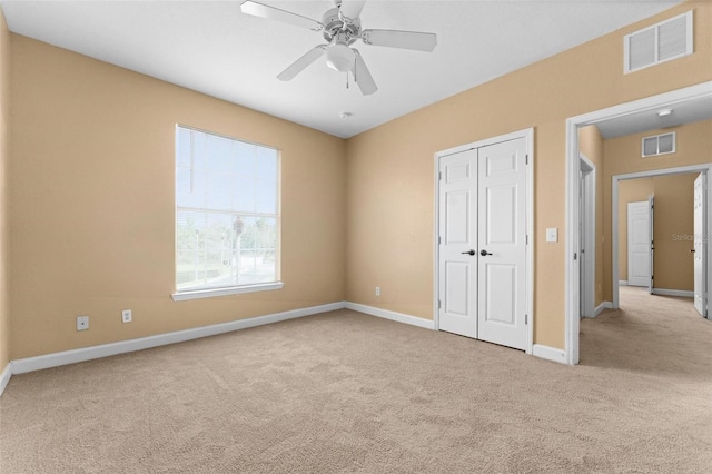 unfurnished bedroom with ceiling fan, a closet, and light colored carpet