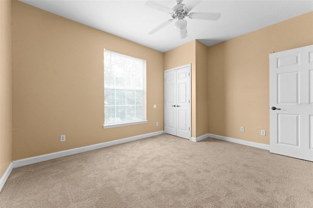 unfurnished bedroom featuring light carpet, ceiling fan, and a closet