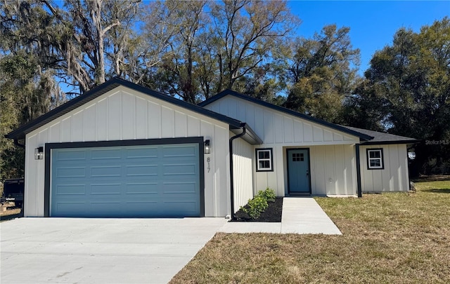 view of front facade with concrete driveway, a front lawn, board and batten siding, and an attached garage