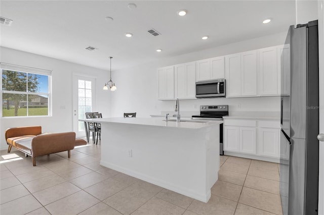 1620 Pelican Dr, Davenport, FL 33896 - kitchen featuring white cabinetry, a center island with sink, stainless steel appliances, and pendant lighting