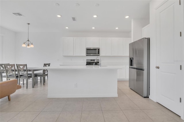 1620 Pelican Dr, Davenport, FL 33896 - kitchen with an island with sink, appliances with stainless steel finishes, pendant lighting, and light tile patterned floors