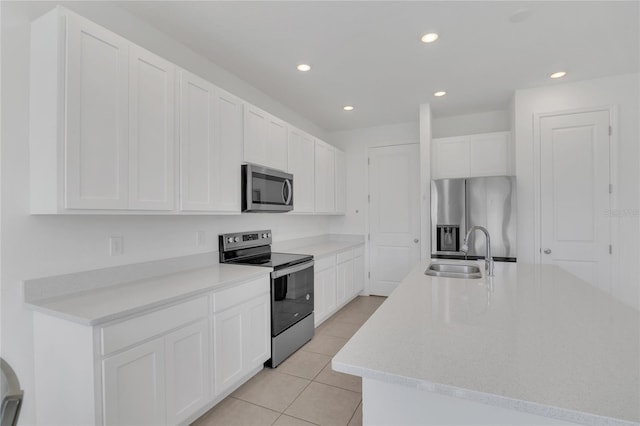 1620 Pelican Dr, Davenport, FL 33896 - kitchen featuring white cabinetry, an island with sink, stainless steel appliances, sink, and light tile patterned floors