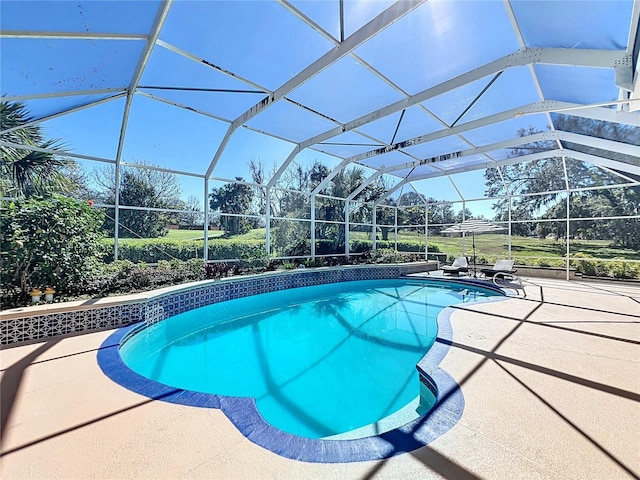 view of swimming pool featuring a patio area and glass enclosure