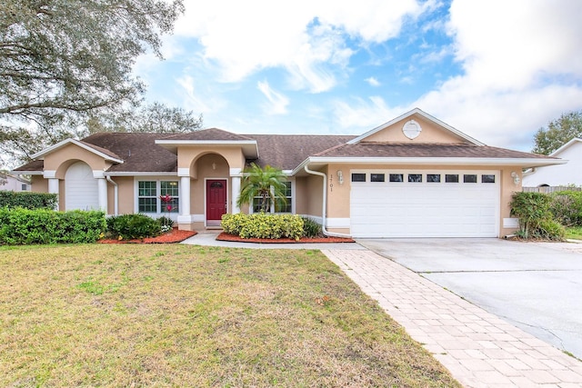 view of front of home featuring an attached garage, a front lawn, concrete driveway, and stucco siding