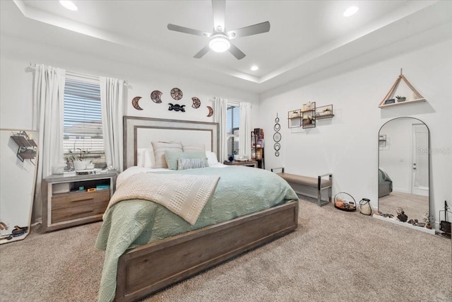 carpeted bedroom featuring a ceiling fan, a tray ceiling, and recessed lighting