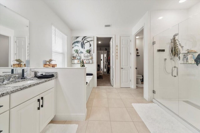 bathroom with visible vents, toilet, vanity, a shower stall, and tile patterned flooring