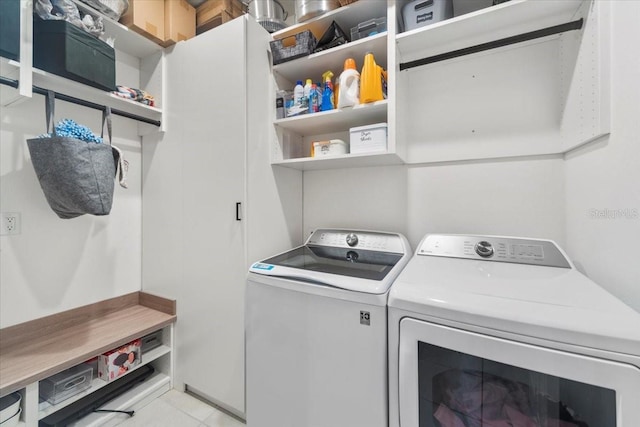 washroom featuring laundry area, light tile patterned flooring, and washing machine and clothes dryer