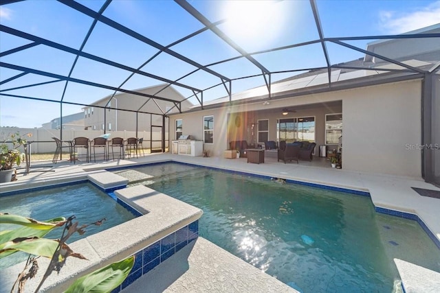 view of swimming pool with exterior kitchen, a patio area, a lanai, and a pool with connected hot tub