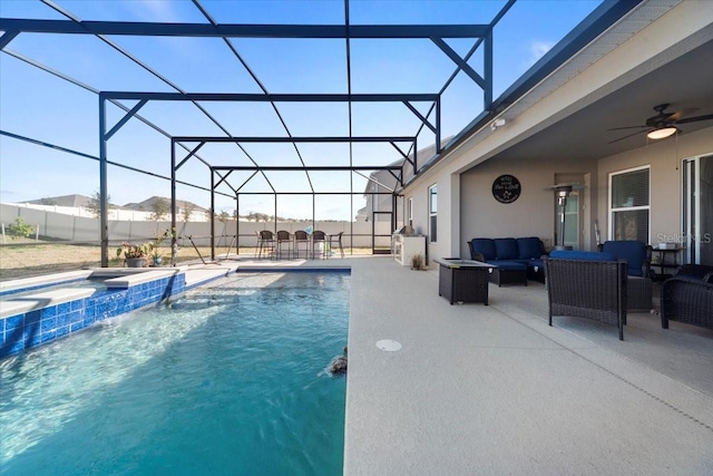 view of swimming pool with glass enclosure, ceiling fan, a patio area, a pool with connected hot tub, and outdoor lounge area