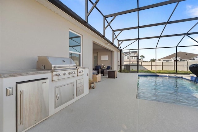 view of pool with an outdoor kitchen, a fenced in pool, a patio, glass enclosure, and grilling area