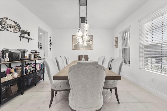 dining room featuring light tile patterned floors, a chandelier, and baseboards