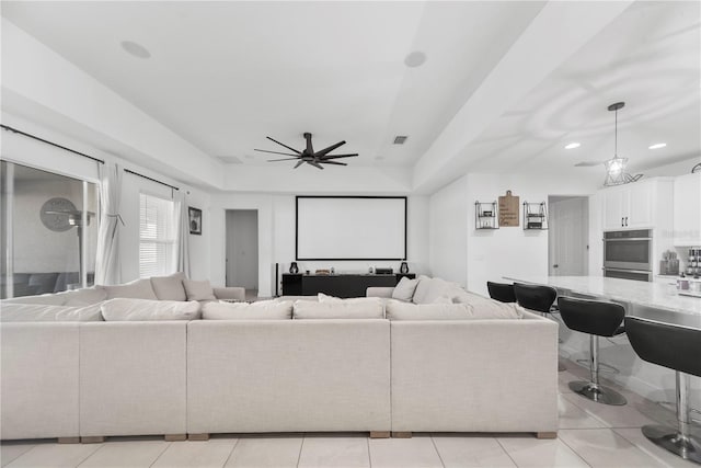 living room with a tray ceiling, recessed lighting, visible vents, light tile patterned flooring, and ceiling fan