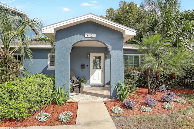 view of exterior entry with stucco siding