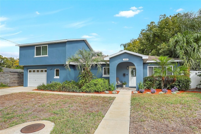 view of front of house featuring an attached garage, driveway, a front lawn, and stucco siding