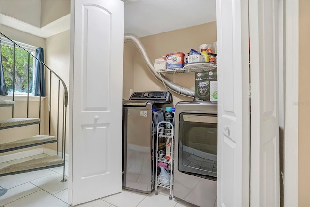 laundry room featuring laundry area, light tile patterned floors, and washer and clothes dryer