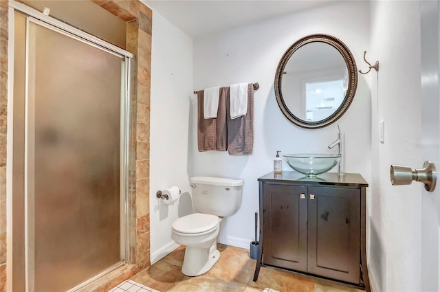 bathroom with toilet, a shower stall, vanity, baseboards, and tile patterned floors