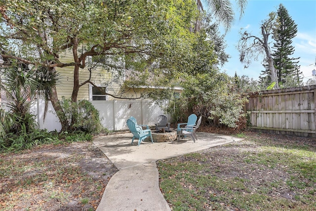 view of yard featuring a fenced backyard, a fire pit, and a patio