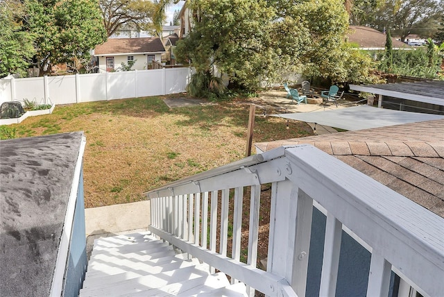 view of yard featuring an outdoor fire pit, a patio, a deck, and fence