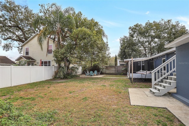 view of yard featuring a fenced backyard, stairs, and a patio