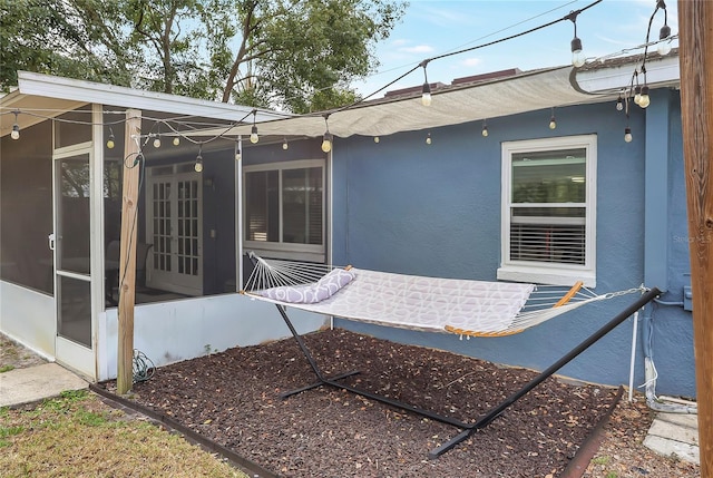 exterior space with stucco siding and french doors