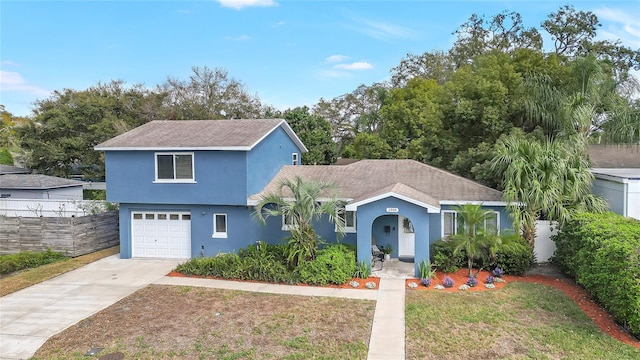 view of front of house with driveway, a front yard, fence, and stucco siding