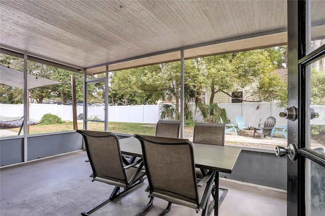 sunroom with an outdoor fire pit, healthy amount of natural light, and outdoor dining area