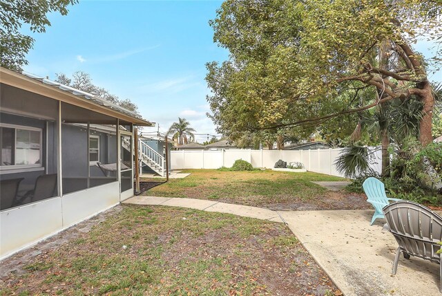 view of yard with a sunroom and a patio