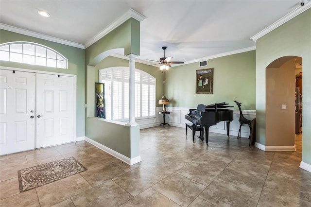 entrance foyer with ceiling fan, ornamental molding, tile patterned flooring, and decorative columns