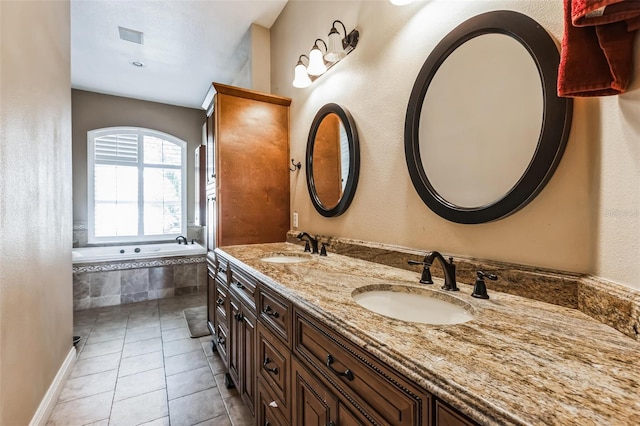 bathroom with tile patterned floors, tiled bath, and vanity