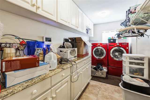 clothes washing area featuring washing machine and dryer, cabinets, and light tile patterned flooring