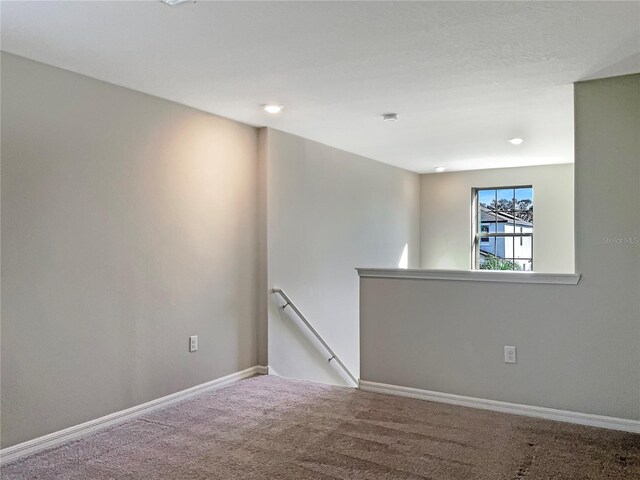 spare room featuring carpet and baseboards