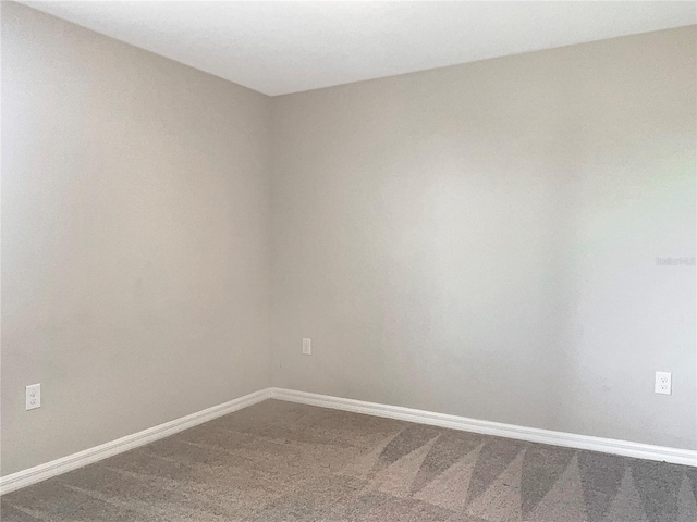 unfurnished room featuring baseboards and carpet flooring