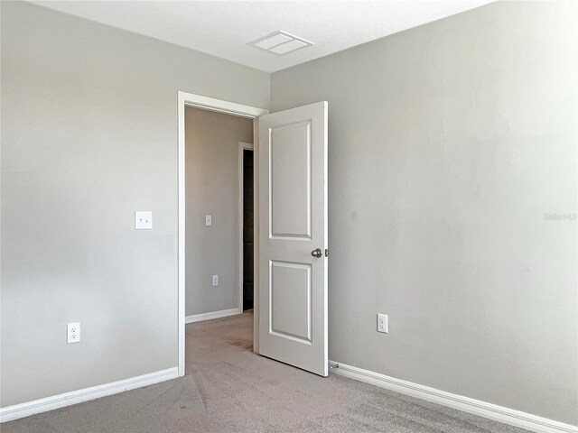 unfurnished room with light carpet, visible vents, and baseboards