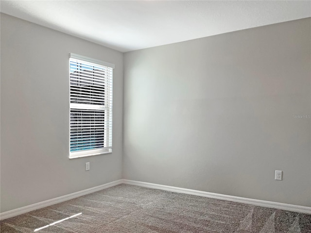 empty room with baseboards and carpet flooring