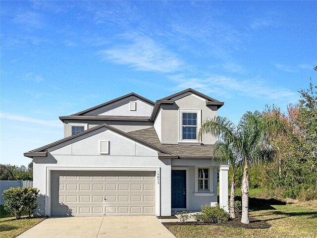 view of front of home with driveway, roof with shingles, a garage, and stucco siding
