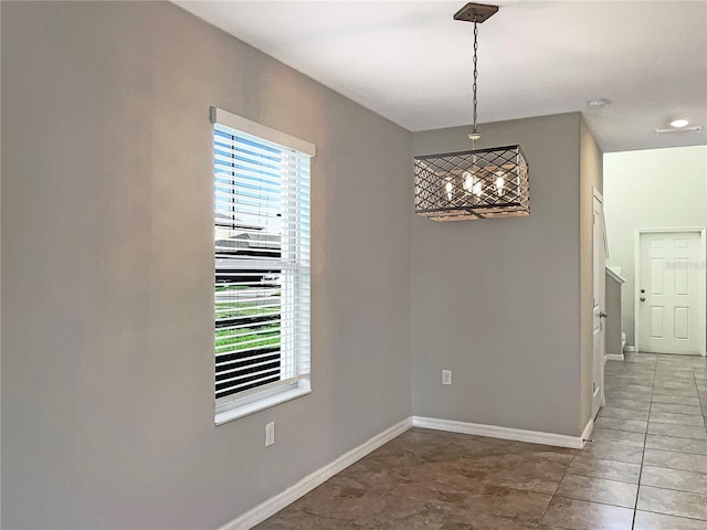 unfurnished dining area featuring a healthy amount of sunlight, baseboards, and tile patterned floors