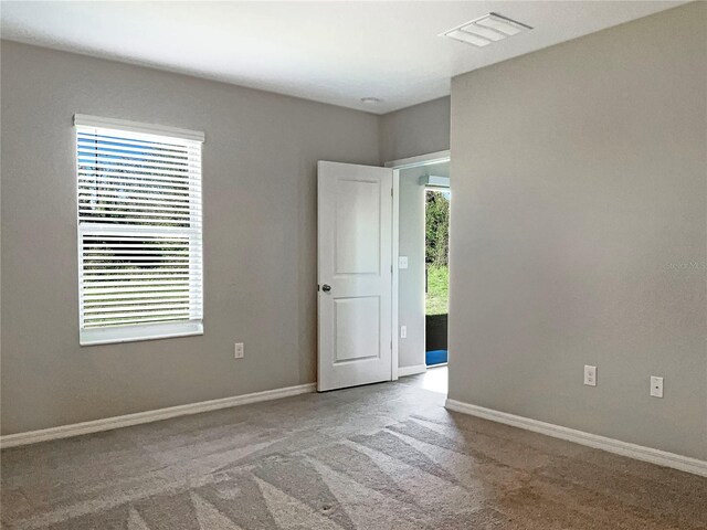 empty room featuring light carpet, baseboards, and visible vents