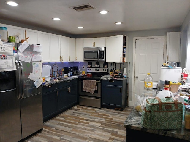 kitchen featuring light wood-type flooring, appliances with stainless steel finishes, white cabinetry, and sink