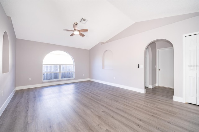 unfurnished room with lofted ceiling, light wood finished floors, baseboards, and a ceiling fan