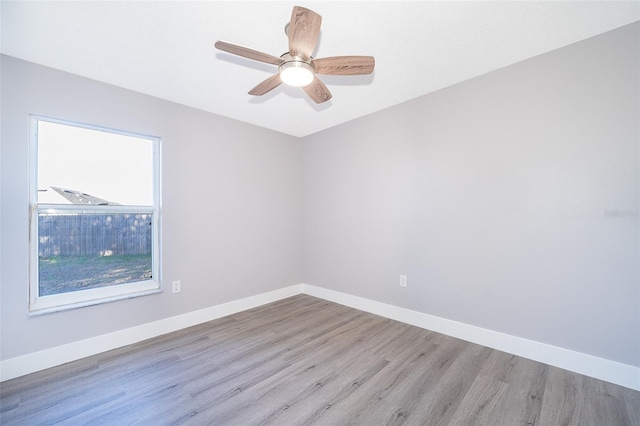 unfurnished room featuring a ceiling fan, light wood-style flooring, and baseboards